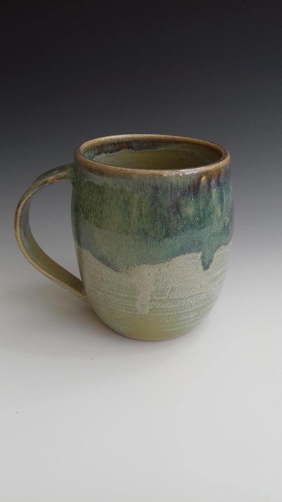 Stoneware mug,
Green glazes overlapped.
